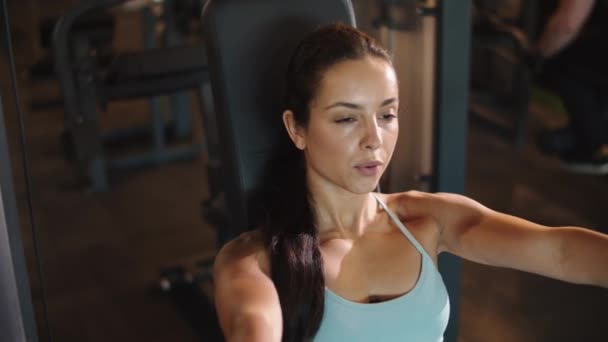 Ragazza in forma premuroso facendo riccioli seduti in palestra. Donna che si esercita nel club sportivo — Video Stock