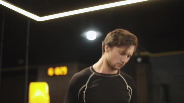 Hombre deportivo guapo usando la cuerda de saltar en el gimnasio. Hombre de fitness saltando en el club deportivo — Vídeo de stock