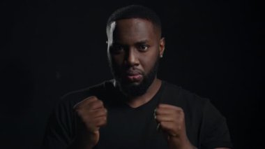 Endişeli adam siyah arka planda ellerini ısıtıyor. Afro adam içeride çığlık atıyor.