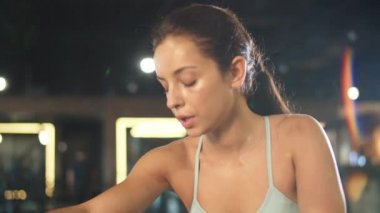 Sportif kız spor salonunda dinleniyor. Spor salonunda oturan bayan sporcu.