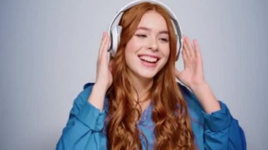 Stüdyoda dans eden neşeli kız. Gri arka planda hareket eden kadın