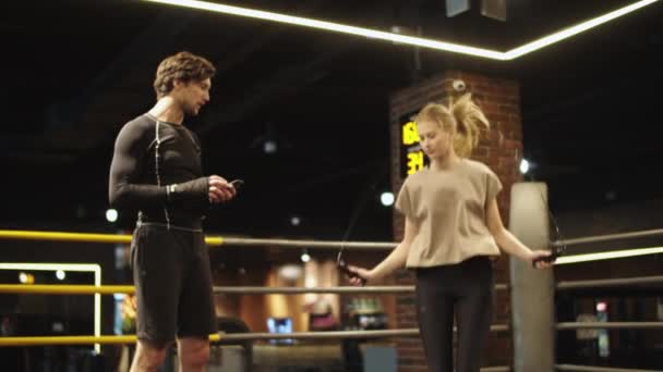 Entrenadora exitosa controlando a la chica en forma en el ring de boxeo. Mujer del deporte saltando en el gimnasio — Vídeos de Stock