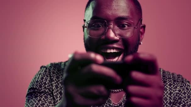 Erfolgreicher Mann gewinnt im Studio. Gewinner afro Kerl mit Smartphone drinnen — Stockvideo