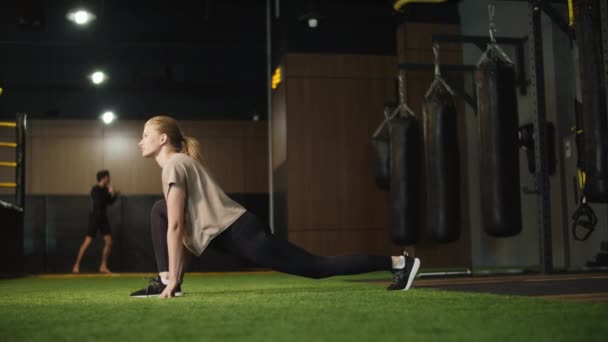 Aktiv fitness kvinna gör stretching i sportklubben. Passform flicka träning på gym — Stockvideo