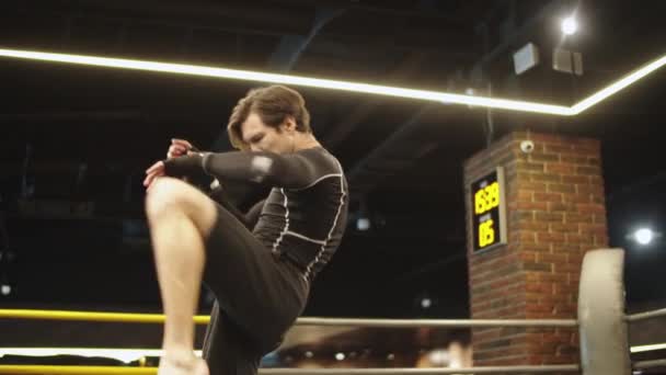 Młody sportowiec rozgrzewa się na siłowni. mężczyzna bokser robi ciosy na pierścień bokserski — Wideo stockowe