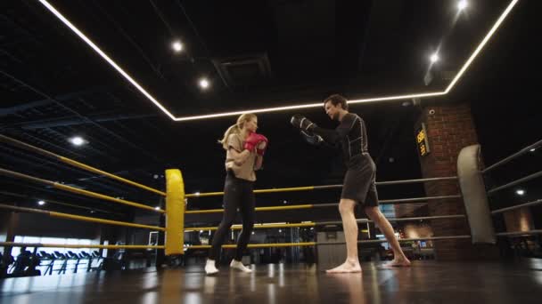 Mujer deportiva estricta haciendo ejercicio en la técnica en el gimnasio. Entrenamiento de chica en forma con entrenador — Vídeos de Stock