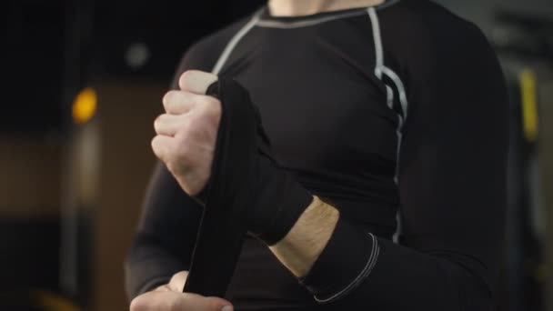 Unrecognizable man ready for fight at gym. Boxer wrapping hands in sport club — Stock Video