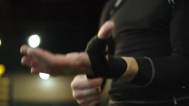 Male person wrapping hands in fitness center. Boxer ready to wear boxing gloves — Stock Video