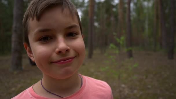 180 stupňů portrét sebevědomého dospívajícího chlapce usmívajícího se do kamery v lese. — Stock video