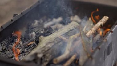 Ormanda barbekü ızgarasında kömür tüttürmek. Açık duman yemek için hazırlanıyor.