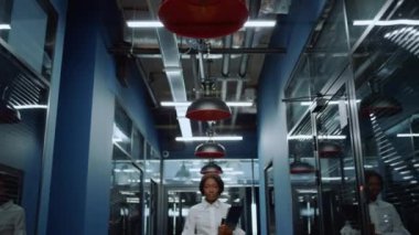 Koridordaki kameraya bakan neşeli afro kadın. Ofiste gülümseyen kadın