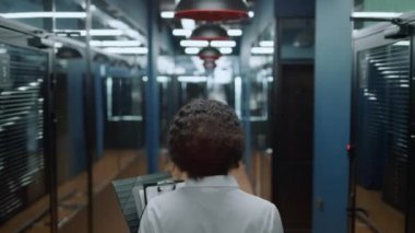 Koridorda buluşmaya giden afro kadın. Ofiste yürüyen iş kadını..