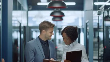 Koridorda tablet kullanan pozitif iş çifti. İş arkadaşları projeyi tartışıyor