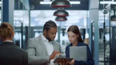 Ofiste çok ırklı bir çift konuşuyor. İş adamı toplantı konusunu kıza gösteriyor