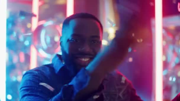 Hombre alegre bailando bajo confeti. Afro chico haciendo movimientos en neón fondo — Vídeo de stock