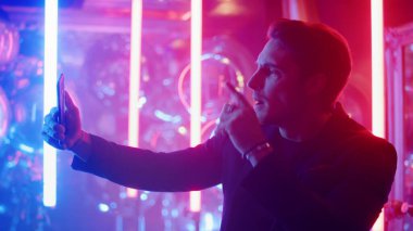 Ciddi bir adamın partide görüntülü görüşmesi var. Adam gece kulübünde videoda sohbet ediyor.