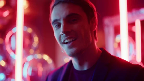 Gece kulübünde elinde kokteyl tutan oyuncu. Neon arka planda eğlenen adam — Stok fotoğraf