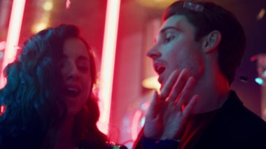 Gece kulübünde dans eden süslü bir çift. Kız ve erkek disko partisinde sarılıyor.