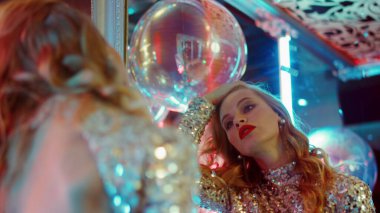 Kulüpte makyaja bakan güzel bir kadın. Partide aynaya bakan kadın