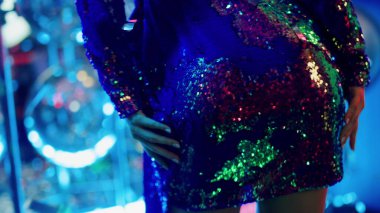 Partide kısa elbiseyle dans eden genç bir kadın. Gece kulübünde kadın poposu