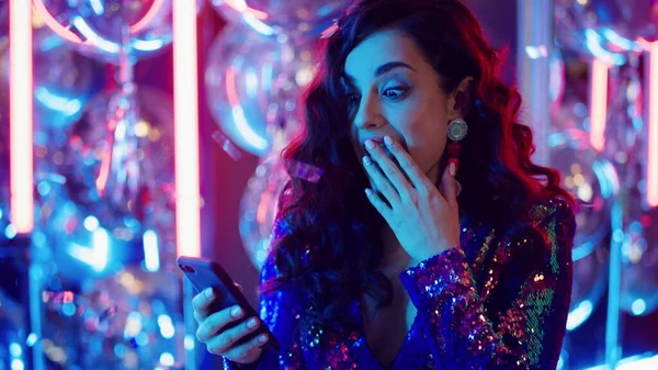 Mujer alegre usando el móvil en la fiesta. Mensaje de texto de persona femenina en el club — Foto de Stock