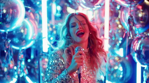 Enerjik bir kadın karaoke yaparken eğleniyor. Partide şarkı söyleyen genç bir kadın
