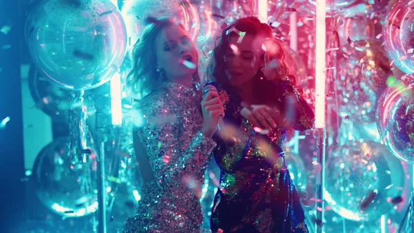 Gece kulübünde neşeli kadınlar şarkı söylüyor. Karaoke 'de şarkı söyleyen seksi kızlar — Stok fotoğraf