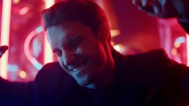 Pozitif adam neon ışıklarla eğleniyor. Gece kulübünde dans eden adam.