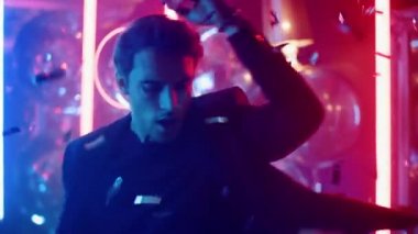 Partide konfeti altında dans eden çekici bir adam. Gece kulübünde dönen adam.