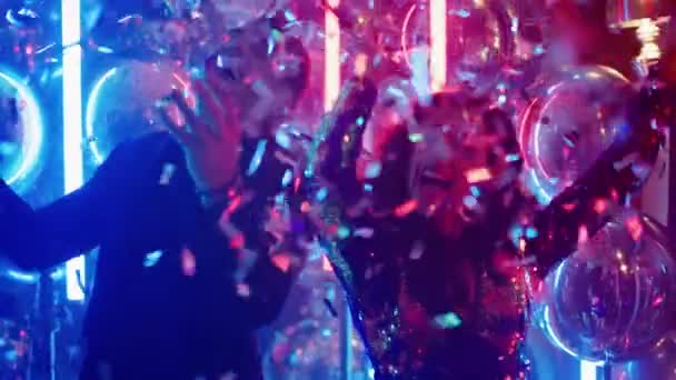 Játékos pár konfettit hányt a partin. Férfi és nő pihenés a klubban — Stock videók