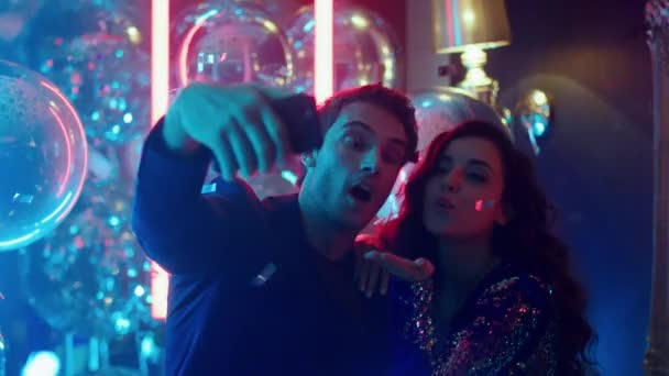 Para kręcąca film w klubie. Słodki mężczyzna i kobieta robi selfie na imprezie — Wideo stockowe