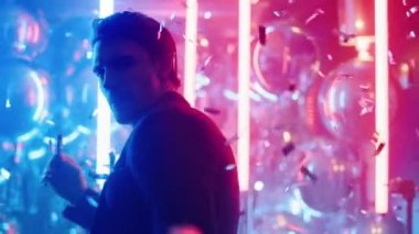 Kulüpte konfeti altında dans eden seksi adam. Neon lambalarda sigara içen adam.