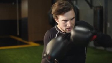 Spor salonunda yumruk pratiği yapan kötü bir sporcu. Spor kulübünde atlet eğitimi
