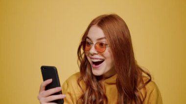 Şaşkın kız cep telefonundan iyi haberler alıyor. Cep telefonu ekranı arayan kadın