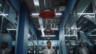 Ofisteki kameraya bakan dost canlısı bir afro adam. İş adamı buluşmayı bekliyor.