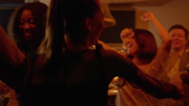 Restoranda çok ırklı bir takım dans ediyor. Mutlu arkadaşlar barda eğleniyor.