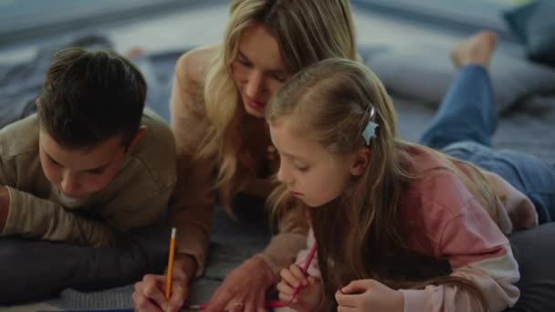 Genç anne ve çocuklar evin içinde resim çiziyorlar. Aile evde eğleniyor. — Stok video