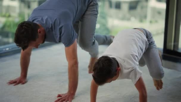 Pai e filho desportivos a treinarem juntos. Pai e criança fazendo exercícios em casa. — Vídeo de Stock