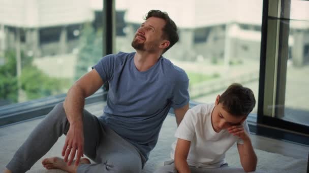 Papá animando a su hijo durante el entrenamiento en casa. Hombre y niño relajándose después del entrenamiento. — Vídeos de Stock