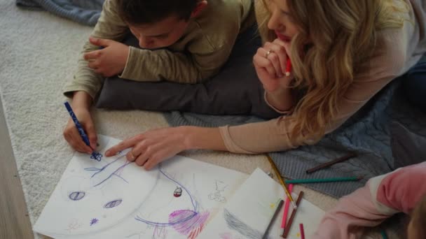 Mãe e crianças fazendo arte em casa. Mãe e crianças deitado tapete com caderno de esboços — Vídeo de Stock