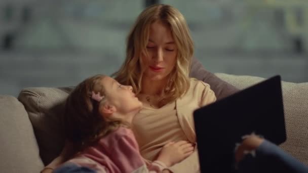 Mãe e filha felizes passando tempo juntas. Mãe abraçando criança no sofá. — Vídeo de Stock