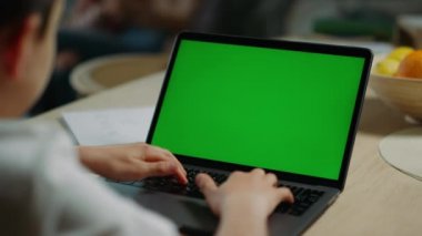 Çocuk internette yeşil ekranda sörf yapıyor. Klavye düzenleme ağ defteri yazan öğrenci