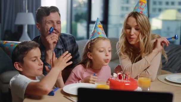 Ragazza che soffia candele sulla torta con i genitori. Famiglia festeggia il compleanno online. — Video Stock