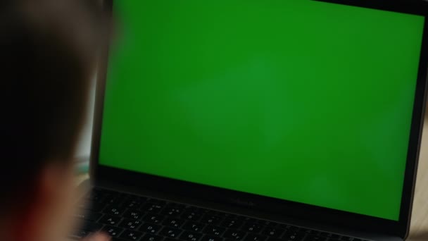 Ragazzo che fa videochiamate con il computer mockup. Bambino guardando computer portatile schermo verde. — Video Stock