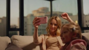 Küçük anne cep telefonuyla selfie çekiyor. Ana kız video kaydediyor