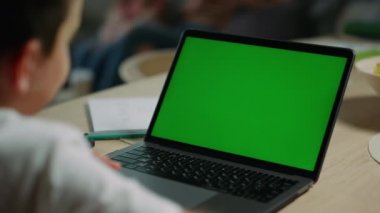 Bilinmeyen çocuk evde online çalışıyor. Krom anahtar dizüstü bilgisayar kullanan bir çocuk..