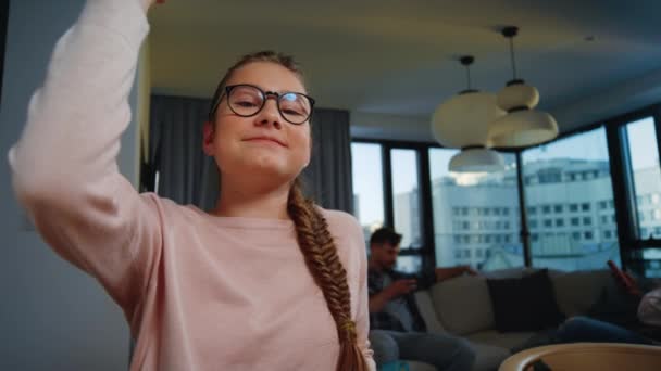 勤勉な女の子の学校の家。オンラインレッスン中に手を上げる眼鏡の女の子 — ストック動画