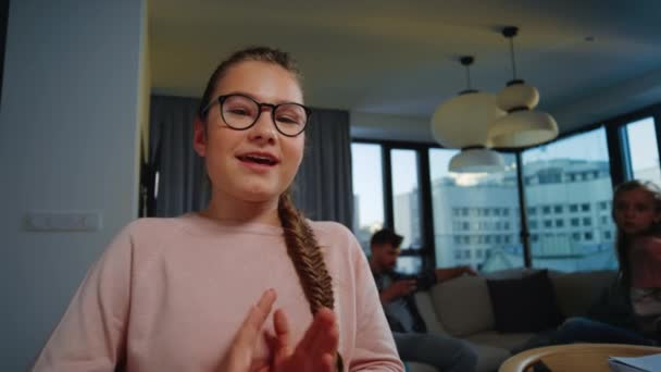 Inteligente estudante aprendendo em casa. Adolescente menina acenando mão para web câmera dentro de casa — Vídeo de Stock