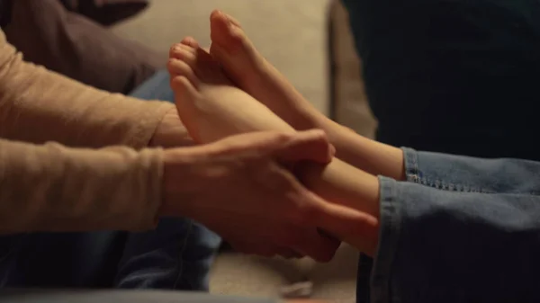 Mother hands holding kid feet at home. Unknown parent arms playing kid legs. — Stock Photo, Image