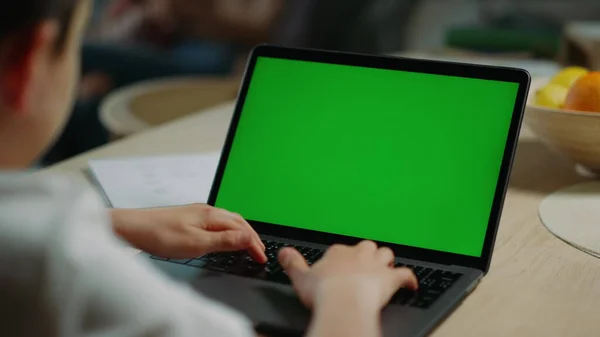 Chłopak surfuje po internecie, zielony laptop. Student wpisując makietę klawiatury netbook — Zdjęcie stockowe